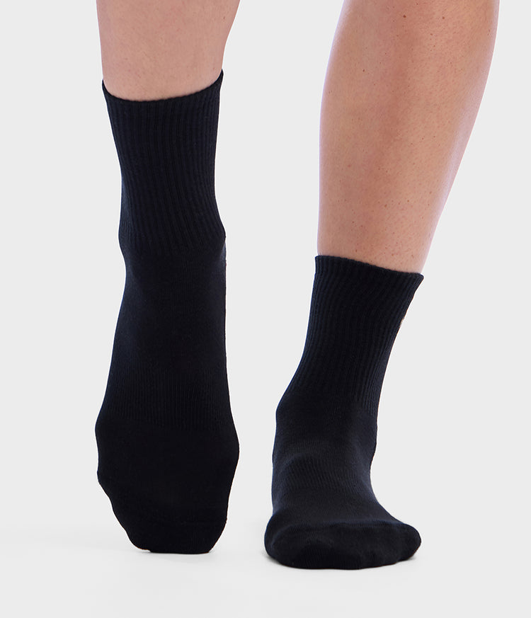Chaussettes basses de Pilates Manduka Equilibria noires portées aux pieds, avec une couverture côtelée de la cheville et un ajustement confortable pour la pratique du Pilates