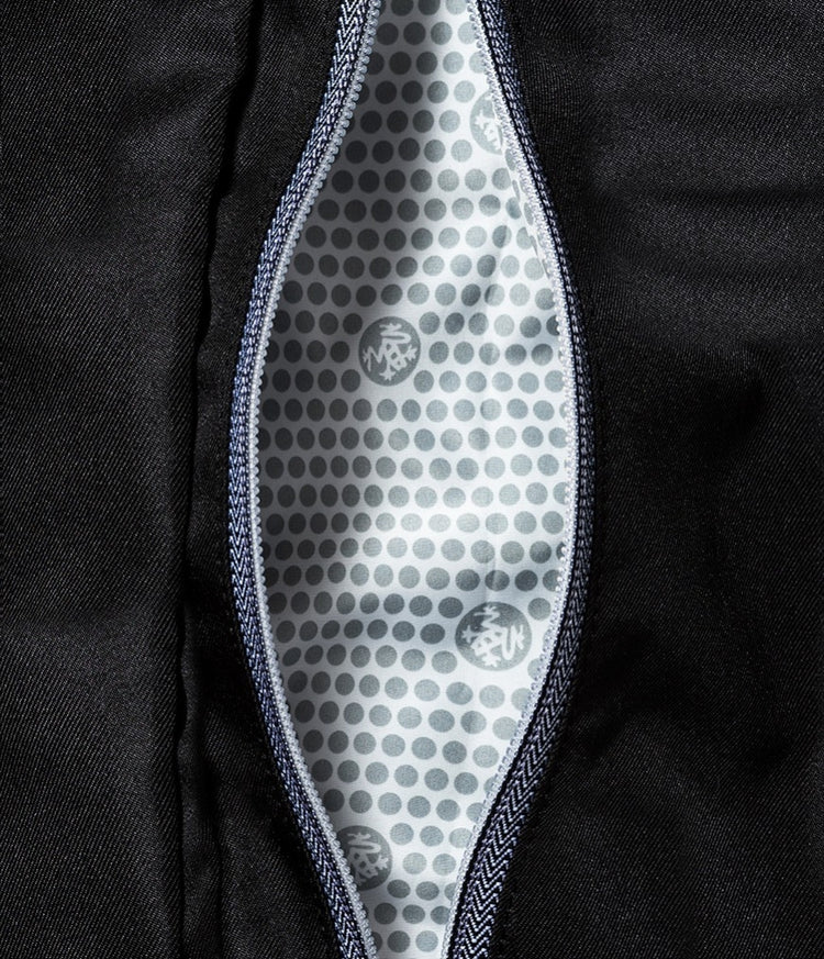 Manduka yoga mat carrier opened to reveal a ventilated gray patterned lining with branded logo details and a zippered compartment